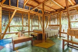 ein Schlafzimmer mit einem Bett und einem Tisch in einem Zimmer in der Unterkunft Universo Pol Bamboo Hostel in Morro de São Paulo