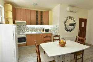 uma cozinha com uma mesa branca, uma mesa e cadeiras em Apartments Brico em Primošten