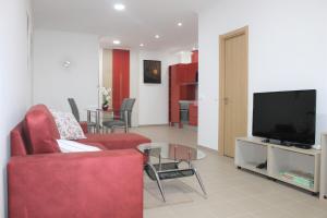 uma sala de estar com um sofá vermelho e uma televisão em Apart Baía do Sado II em Setúbal
