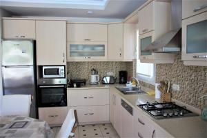 una cucina con mobili bianchi e un forno a piano cottura di Dalyan Villa Amazon a Dalyan