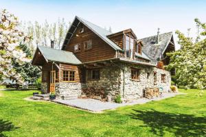 a large wooden house with a green yard at Galexy Lounge in Burkes Pass