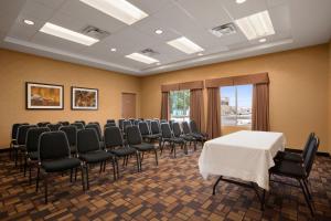 une salle de conférence avec une table et des chaises blanches dans l'établissement Days Inn & Suites by Wyndham Winnipeg Airport Manitoba, à Winnipeg