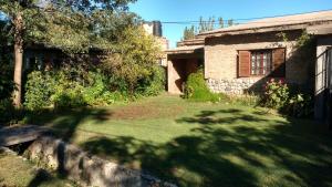 una casa vieja con un patio con un árbol en Casa de descanso "El Jagüel", en San Marcos Sierras