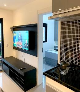 a living room with a flat screen tv on the wall at Apartamento Completo LUX com Piscina na Cobertura, República in Sao Paulo