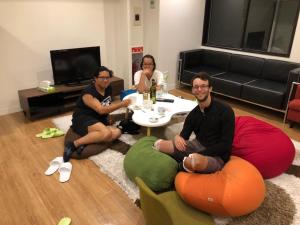 a group of three people sitting around a living room at Guesthouse TOHO in Nagoya