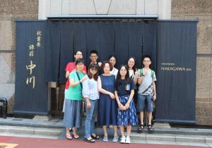 um grupo de pessoas posando para uma foto em frente a um portão em Akihabara Nakagawa Inn em Tóquio