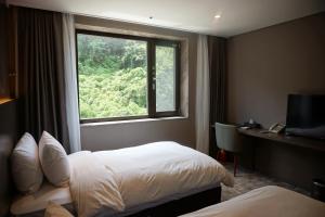 um quarto de hotel com duas camas e uma janela em Mudeung Park Hotel em Gwangju