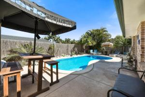 a swimming pool with a table and an umbrella at Sweetbrush Place in Mooloolaba