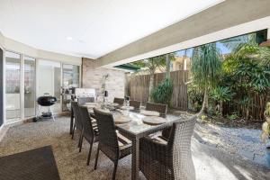 uma sala de jantar com mesa e cadeiras em Sweetbrush Place em Mooloolaba