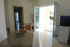 a living room with a table and chairs and a television at Self contained apartment with private kitchen Higher Heights, Barbados in Christ Church