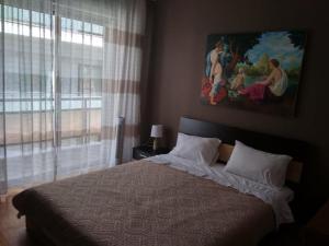 - une chambre avec un lit orné d'une peinture murale dans l'établissement Konstantin Apartment, à Kavala