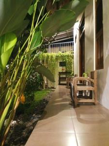 a walkway with benches and plants in a building at Doeloerkoe Homestay in Solo