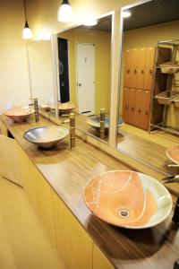 La salle de bains est pourvue de lavabos et de miroirs sur un comptoir. dans l'établissement K's House Hokkaido - Asahidake Onsen Hostel, à Higashikawa