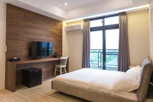 a hotel room with a bed and a flat screen tv at DoMo Yilan in Yuanshan