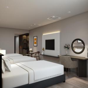 Thanh HóaにあるDai Viet Hotelのベッド4台と鏡が備わるホテルルームです。
