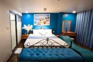 a bedroom with blue walls and a bed with a blue couch at Cozi 9 Hotel - Theme Hotel in Kiến An