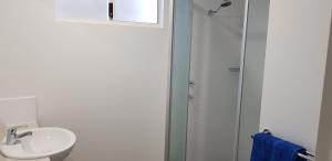 a bathroom with a shower, toilet, and sink at Kalbarri Red Bluff Tourist Park in Kalbarri