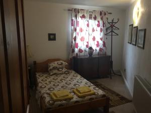 a small bedroom with a bed and a window at Villa Draganovi in Kamen Bryag