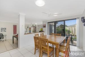 a dining room with a wooden table and chairs at Oceania Beach Paradise LJHooker Yamba in Yamba