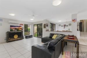 a living room with a couch and a fireplace at Oceania Beach Paradise LJHooker Yamba in Yamba