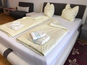 duas camas com toalhas e almofadas por cima em Komfortables Appartement/Garconniere in Graz für Urlaub und Geschäftsreisen em Graz