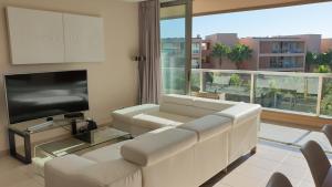 a living room with a couch and a flat screen tv at Apartamento Salgados Beach in Albufeira