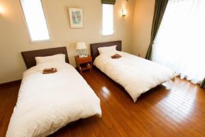 浦安市にあるUrayasu Guesthouse 浦安ゲストハウスのベッド2台が隣同士に設置された部屋です。