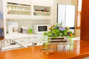 un vaso di fiori seduto sopra un bancone della cucina di Urayasu Guesthouse 浦安ゲストハウス a Urayasu