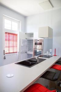a white kitchen with a sink and an oven at Cottage de la Tour - Duplex troglodyte of 100 m in Azay-le-Rideau