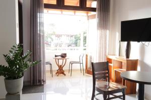 a living room with a large window and a table and chairs at Villa Agoura Grand Negombo in Negombo