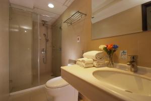 a bathroom with a sink and a shower and a toilet at The Metro Hotel Taichung in Taichung