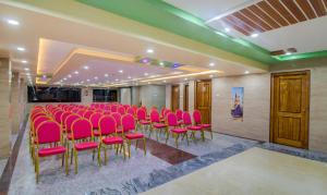 een conferentieruimte met roze stoelen en tafels bij Treebo Trend Sls Grand in Tirupati