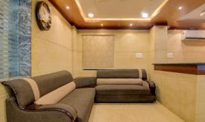 een wachtkamer met twee stoelen en een scherm bij Treebo Trend Sls Grand in Tirupati