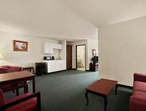 a living room with a couch and a table at Days Inn & Suites by Wyndham Romeoville in Romeoville