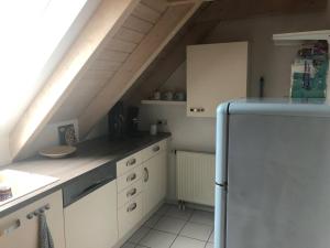 eine Küche mit weißen Schränken und einem Kühlschrank in der Unterkunft Ferienwohnung Ankerplatz Bodensee in Uhldingen-Mühlhofen