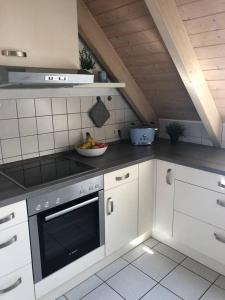 a kitchen with a stove and a bowl of fruit at Ferienwohnung Ankerplatz Bodensee in Uhldingen-Mühlhofen