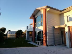 uma casa com um alpendre e um relvado em Whaka Heights em Christchurch