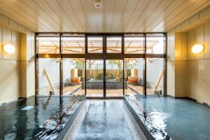 a pool of water in a room with glass doors at Fujikawaguchiko Resort Hotel in Fujikawaguchiko