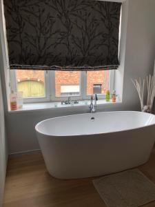 a bath tub in a bathroom with a window at Home Bruges Cosy Comfort Modern Couple Privacy walking distance City center Kitchen Terrace Garden in Bruges