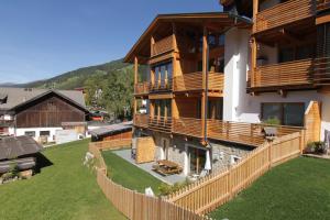 a large house with a fence in front of it at Almrausch Apartments in Sesto