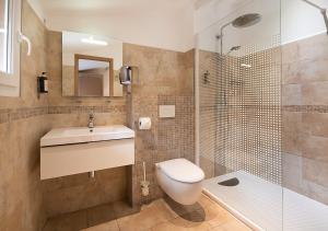 a bathroom with a toilet and a sink and a shower at Holzer II in Porto-Vecchio