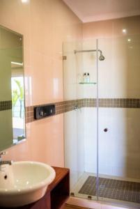 a bathroom with a sink and a glass shower at The Tides Inn in Durban