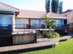 una casa con terraza con mesas y sillas en The Tides Inn, en Durban