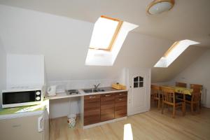 a kitchen and dining room with skylights in an attic at Dworek Łeba in Łeba