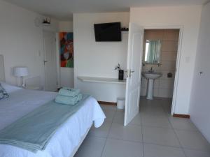 a bedroom with a bed and a tub and a sink at Berg en Dal Accommodation in Saldanha