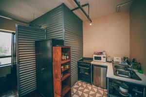 a kitchen with a black refrigerator and a microwave at Cozy, Modern Living in Maboneng: 104 in Johannesburg