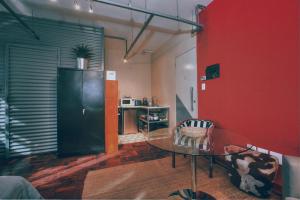 a room with a glass table and a red wall at Cozy, Modern Living in Maboneng: 104 in Johannesburg