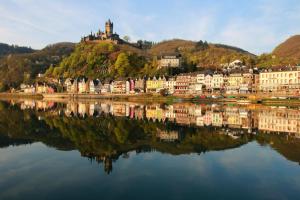a town on a hill next to a body of water at Feriendomizil Zur Burg in Cochem
