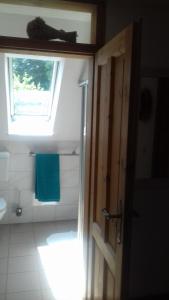 a bathroom with a window and a sink and a toilet at Haus Wiesengrund in Rauhenebrach