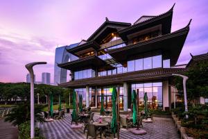 a building with tables and chairs in front of it at Tonino Lamborghini Hotel Suzhou in Suzhou